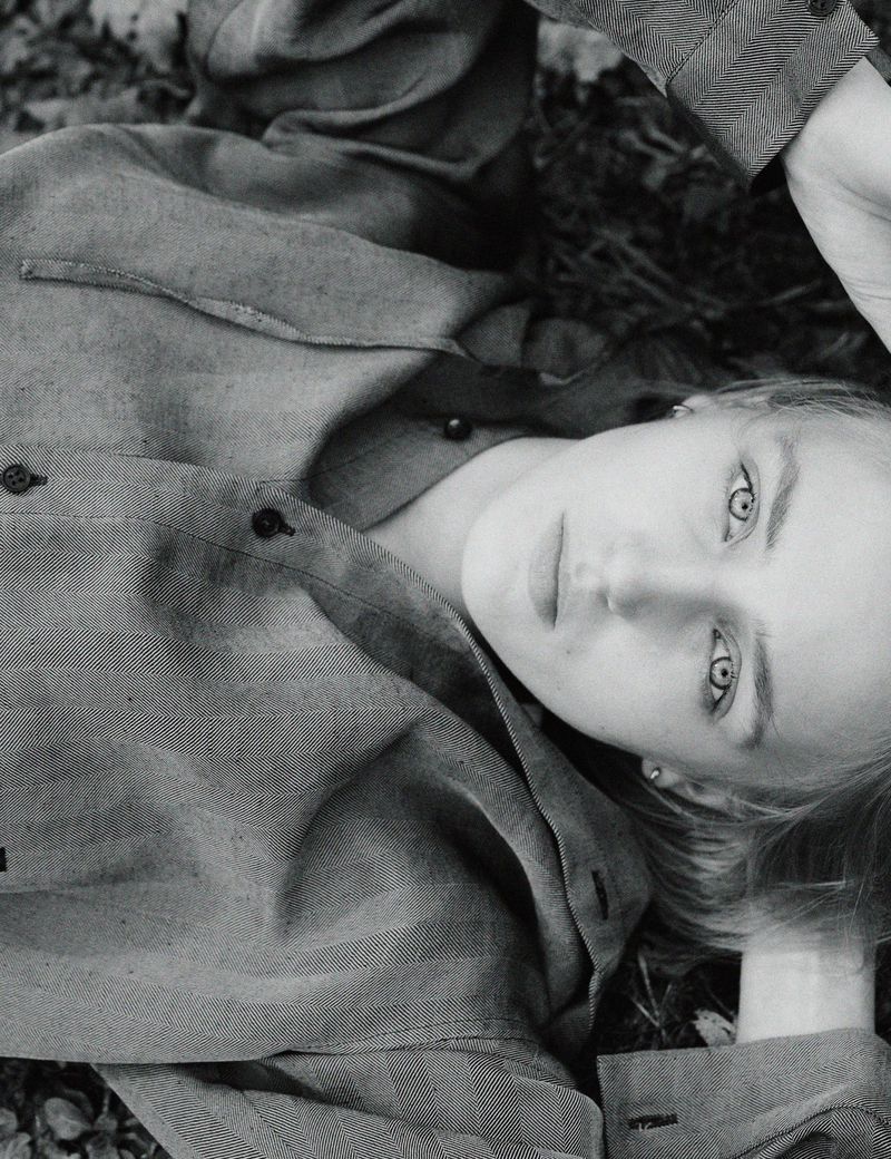 Model George Anderson lying on woodland ground wearing patterned long-sleeve shirt in Pop Magazine editorial by Charlotte Stouvenot.