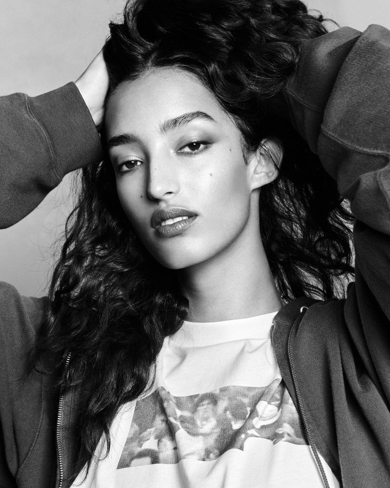 Model Mona Tougaard holding her dark curly hair with both hands in a black and white portrait by Luigi and Iango.