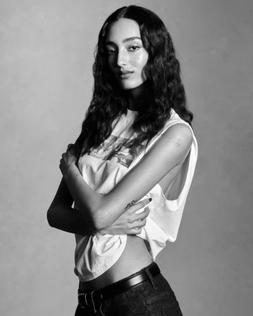 Mona Tougaard wearing a white sleeveless top and dark jeans against a neutral studio backdrop in a black and white portrait.