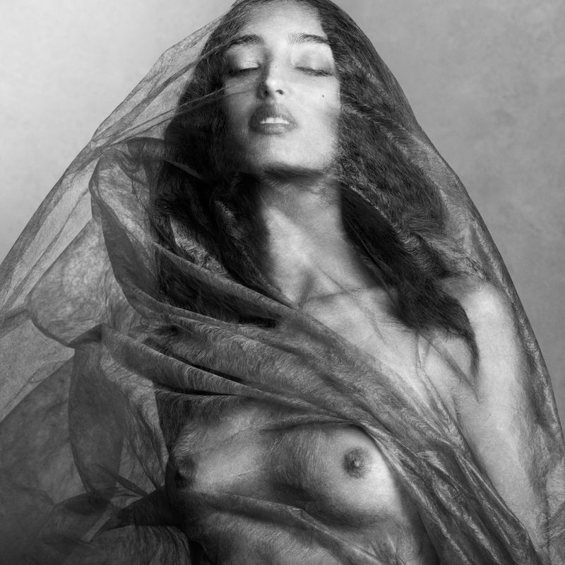 Mona Tougaard draped in sheer dark fabric with eyes closed in a black and white portrait by Luigi and Iango.
