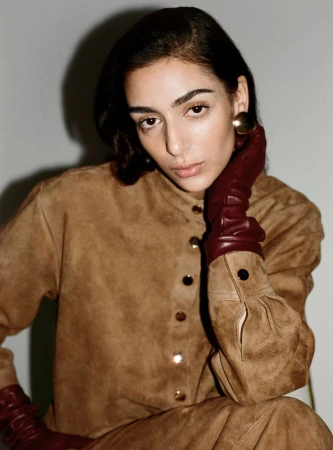 Model Nora Attal in a brown suede top with burgundy leather gloves for Nour Hammour Spring Summer 26
