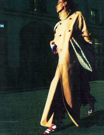 Model in a long tan trench coat walking outdoors at night on a dark street for The Face Magazine editorial Women of Frequency