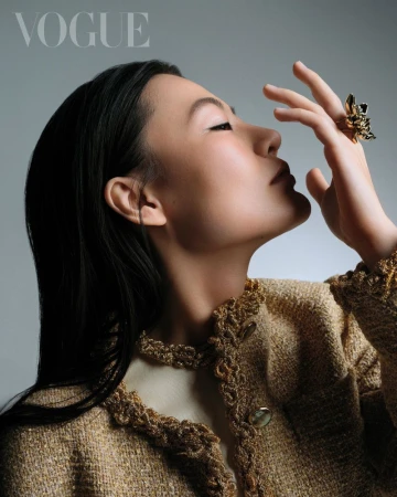 Portrait of Zine Tseng wearing a textured gold jacket with a sculptural ring for Vogue Taiwan