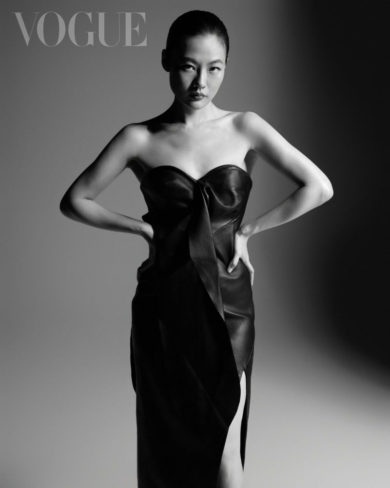 Model in strapless black gown posing against a grey gradient backdrop with dramatic lighting for Vogue Taiwan