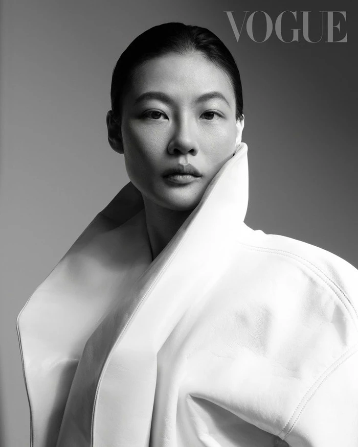 Portrait of a woman wearing a high-collared white coat against a seamless grey backdrop for Vogue Taiwan.