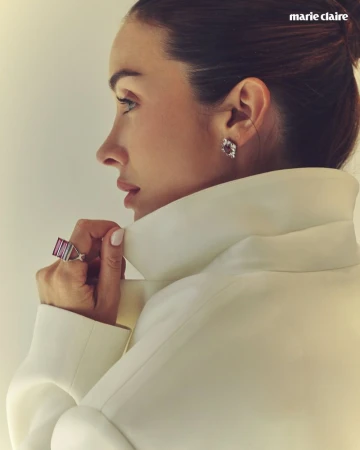 Profile portrait of a woman wearing a white high-collar coat, gemstone ring, and diamond earrings for Marie Claire Mexico.
