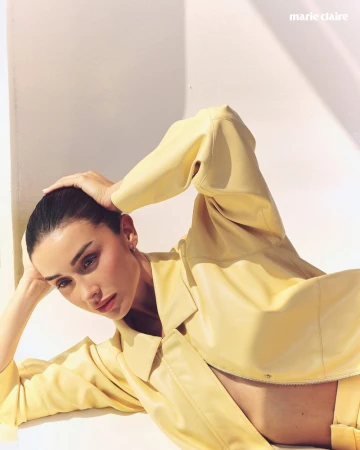Model in a yellow leather jacket reclining against a white wall for Marie Claire Mexico editorial