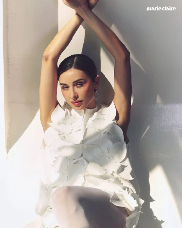 Model Claudia Bouza with arms raised wearing a white floral applique dress for Marie Claire Mexico