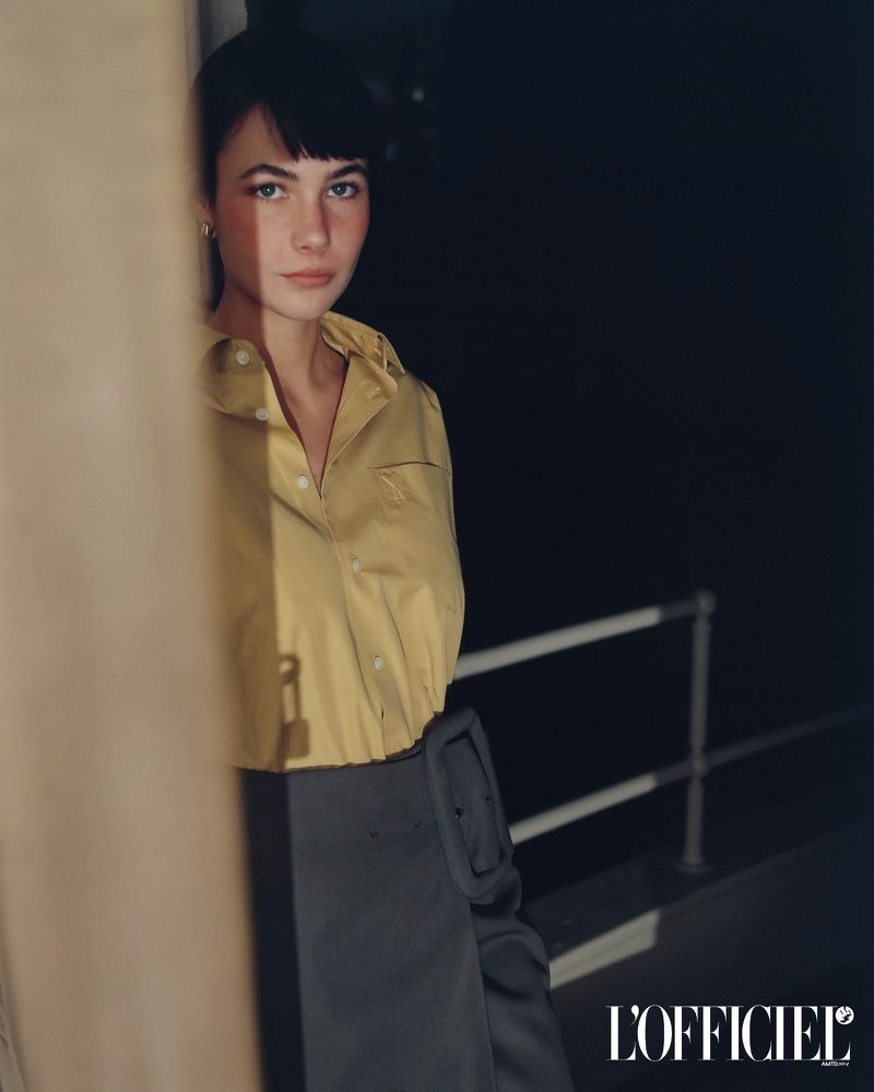 Model Grace Burns wearing a mustard yellow button-down shirt outdoors at night for L'Officiel USA editorial photography.