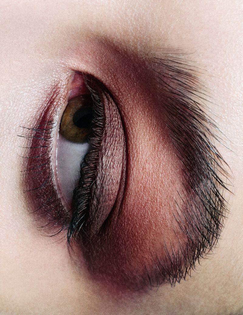 Close-up macro photography of a human eye with dark burgundy eyeshadow and detailed long eyelashes for Schön! Switzerland.