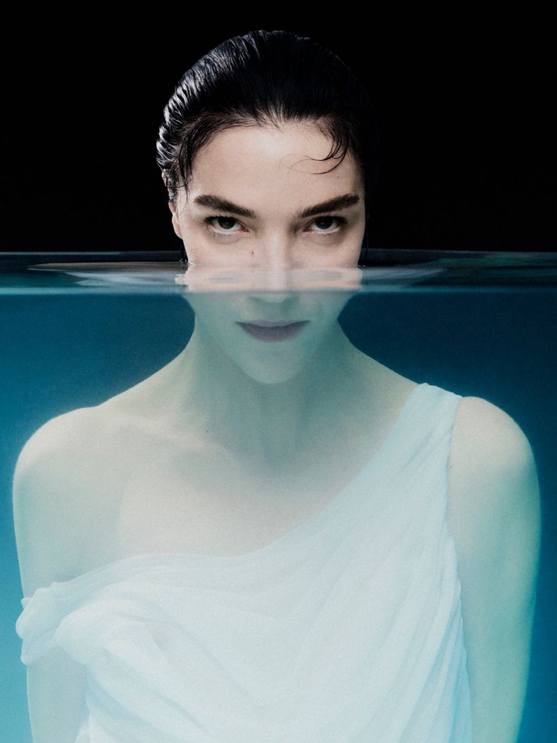 Model Mariacarla Boscono partially submerged in water wearing a white garment for the Mariacarla x Acqua FIUGGI campaign