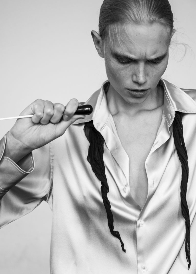Model Sasha Dom holding a conductor baton in a satin shirt for 5ELEVEN Magazine editorial photographed by Edwin S Freyer.