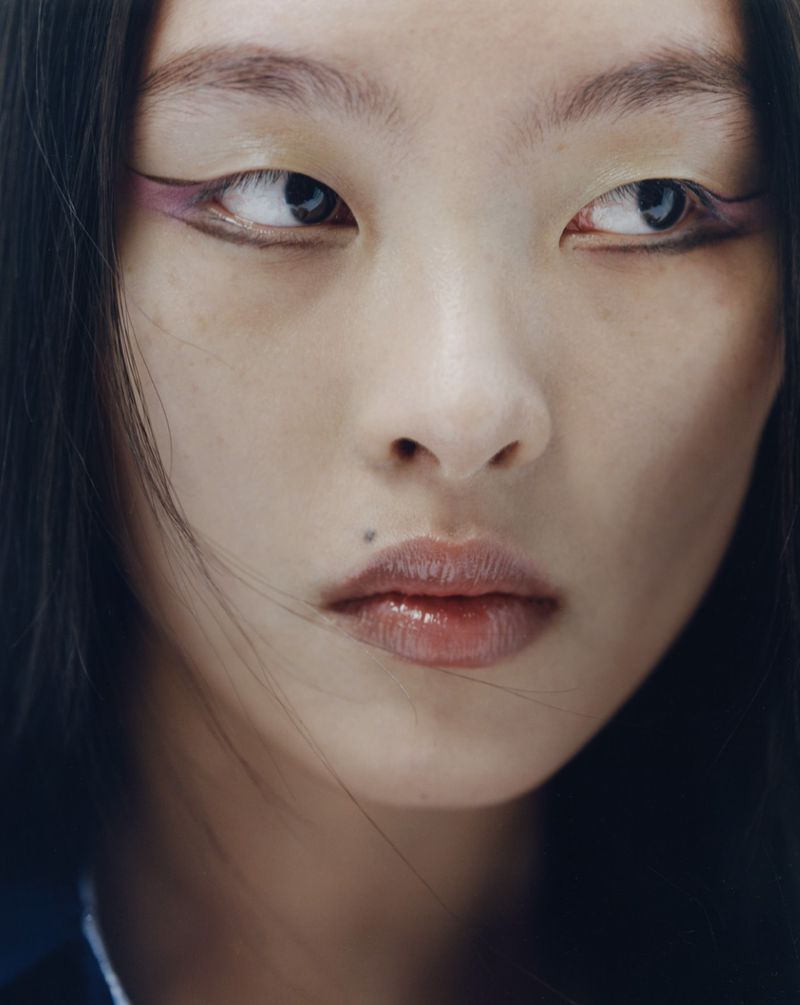 Close up beauty portrait of an east asian woman with graphic purple eyeliner and glossy lips for Puss Puss Magazine
