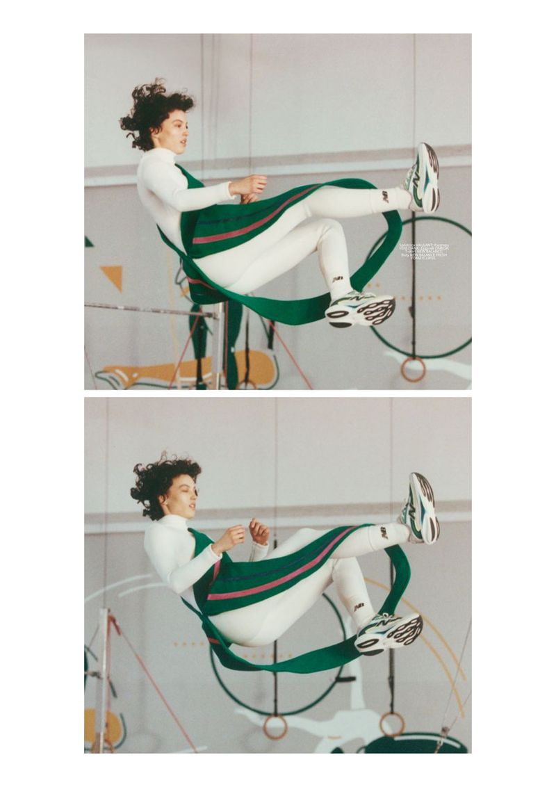 Model suspended mid-air in white athletic wear and a green strap garment against a gym background for Vogue Polska