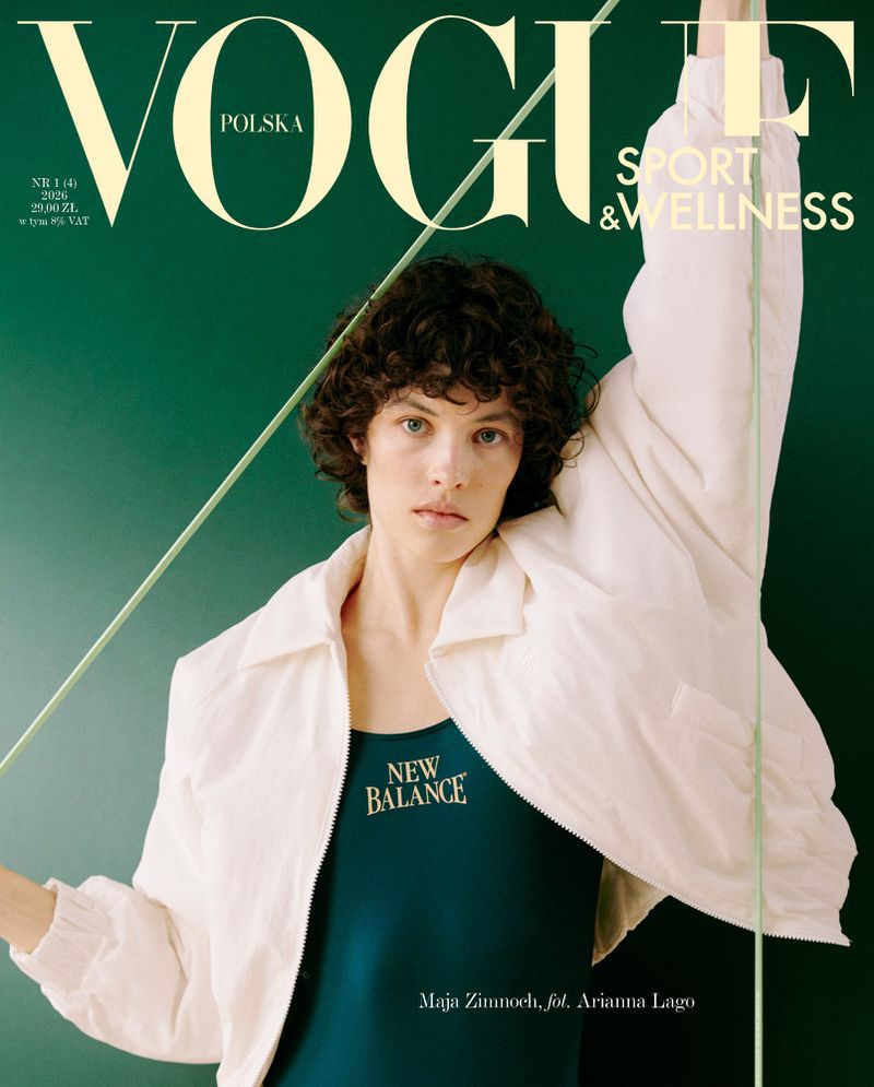 Magazine cover featuring a model with curly dark hair wearing a white jacket and a dark green tank top against a green background