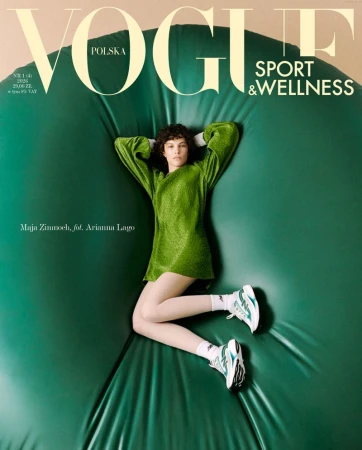 Model with curly hair in green dress and sneakers lying on puffed green backdrop for Vogue magazine cover