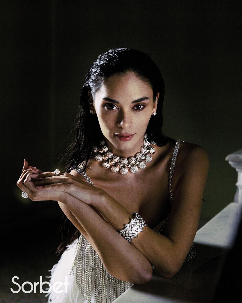 Woman wearing jewelled statement necklace and rings leaning on a ledge for Sorbet Magazine project Pia Jauncey