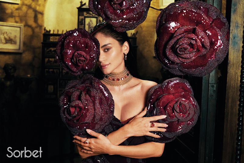 Woman wearing ornate gold choker and holding large dark red sequined rose accessories for Sorbet Magazine project Pia Jauncey.