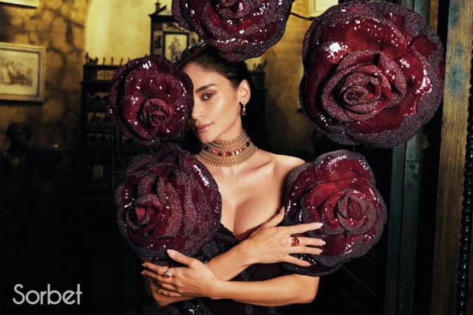 Woman wearing ornate gold choker and holding large dark red sequined rose accessories for Sorbet Magazine project Pia Jauncey.