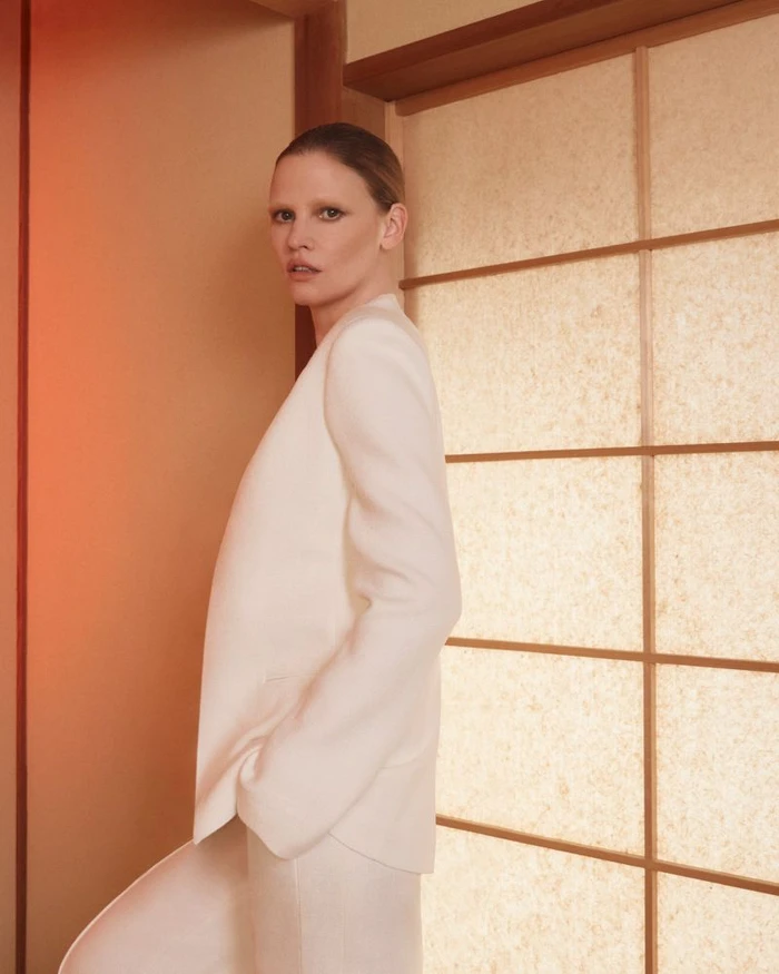 Model Lara Stone wearing a white blazer in front of a shoji screen for the Adam Lippes Spring 2026 Campaign.
