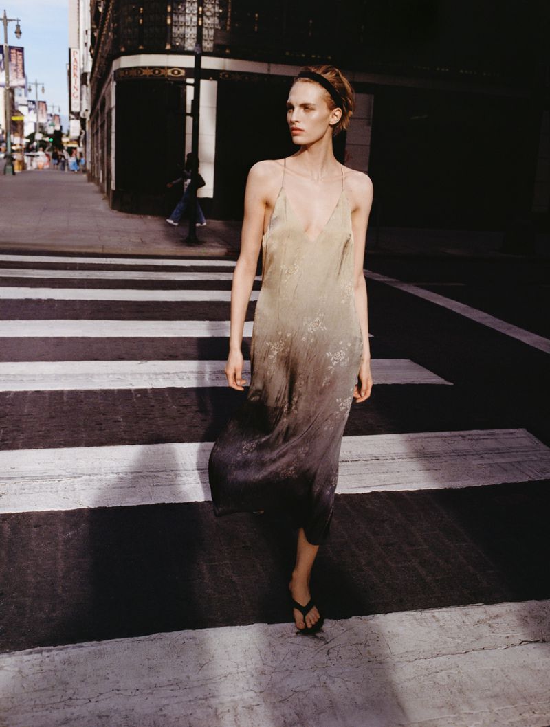 Model in a gradient slip dress walking across a city street crossing