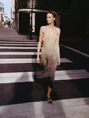 Model in a gradient slip dress walking across a city street crossing