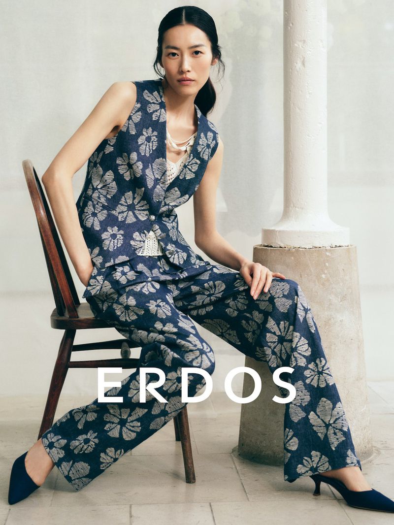 Model Liu Wen wearing a blue floral vest and matching trousers seated on a wooden chair for Erdos