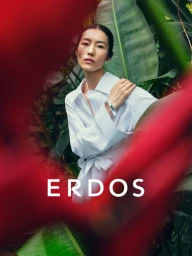 Model Liu Wen wearing a white shirt amid lush tropical foliage with blurred red foreground framing