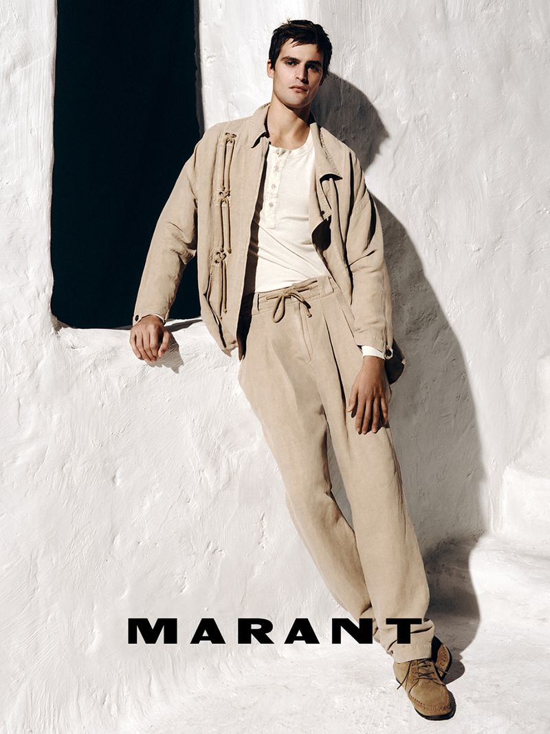Parker Van Noord in beige jacket and trousers leaning against a white textured wall for Isabel Marant campaign