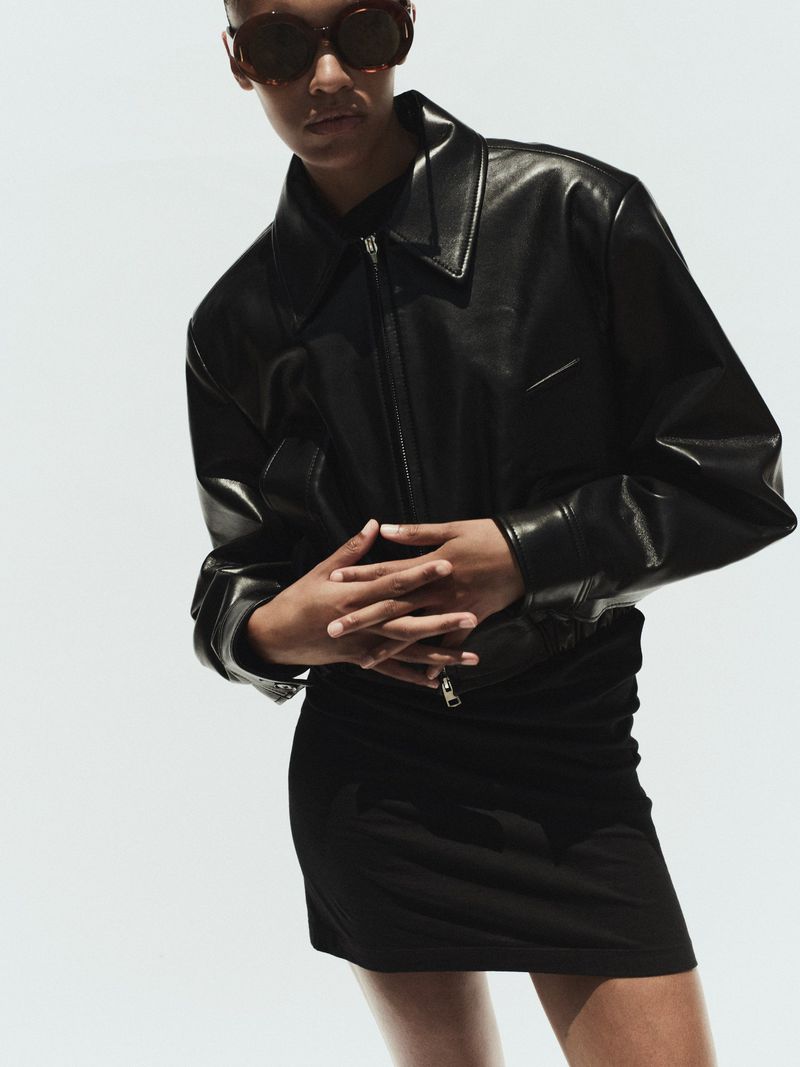 Model wearing a black leather jacket and sunglasses against a plain white background for AGOLDE Spring 2026