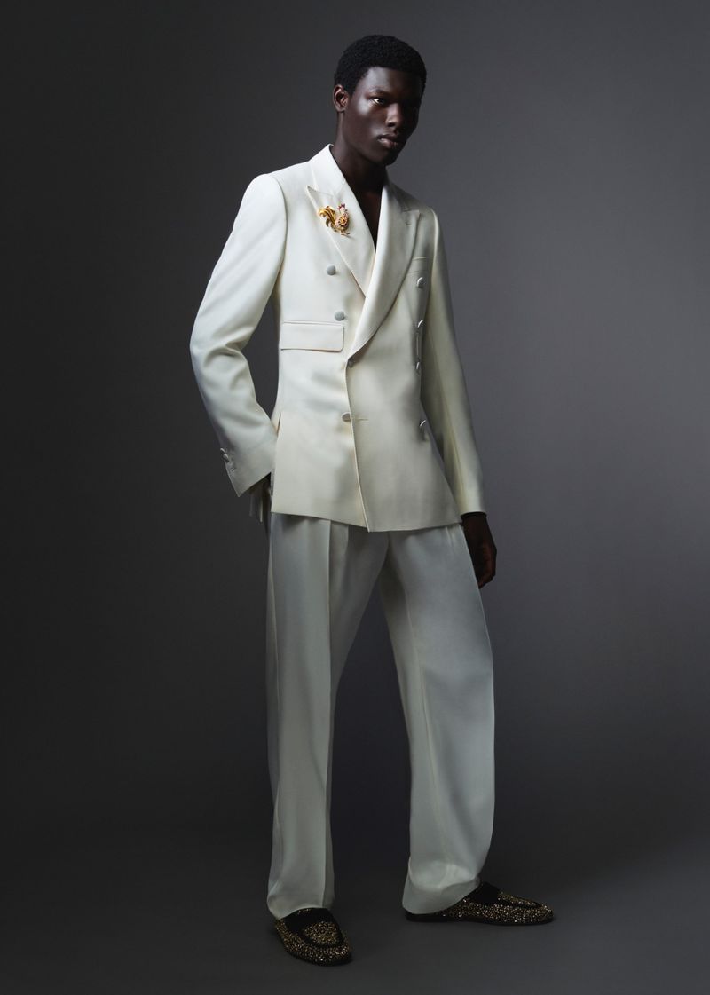 Black man wearing a white double-breasted suit against a dark grey studio background for Dolce and Gabbana Mens S/S 26