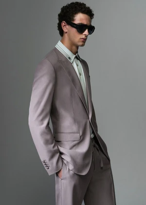 Model wearing a tailored taupe suit jacket and sunglasses against a grey backdrop for Dolce & Gabbana Mens S/S 26