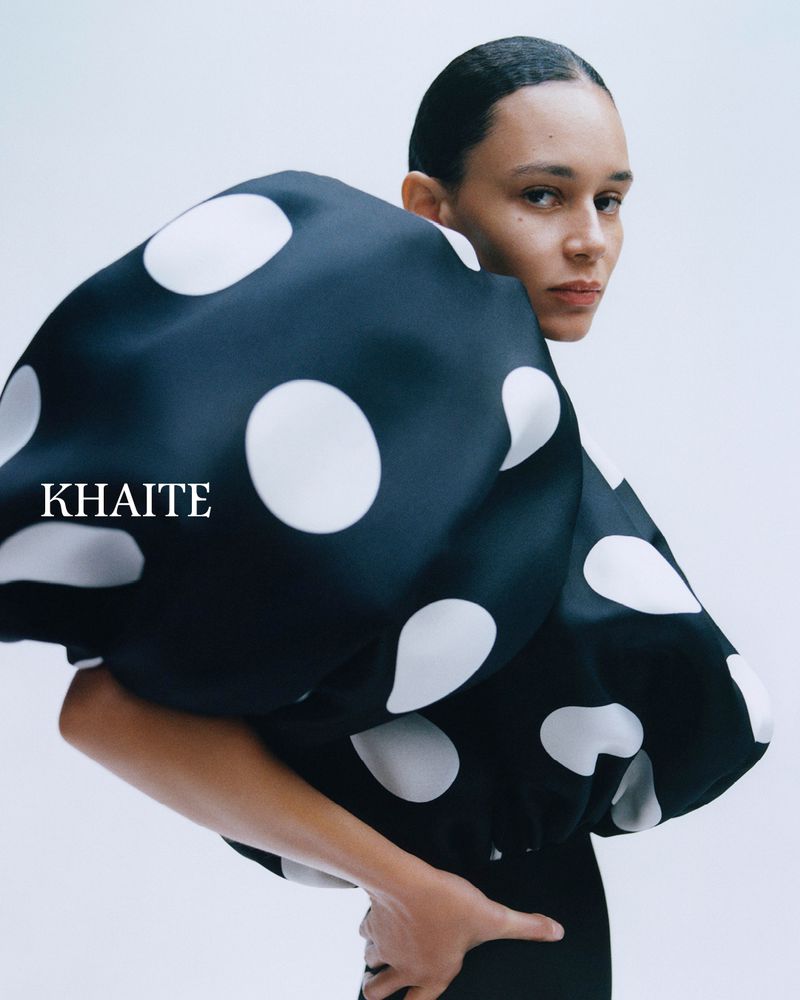 Model Binx Walton wearing a black and white polka dot sculptural top for Khaite S/S 2026 against a plain background
