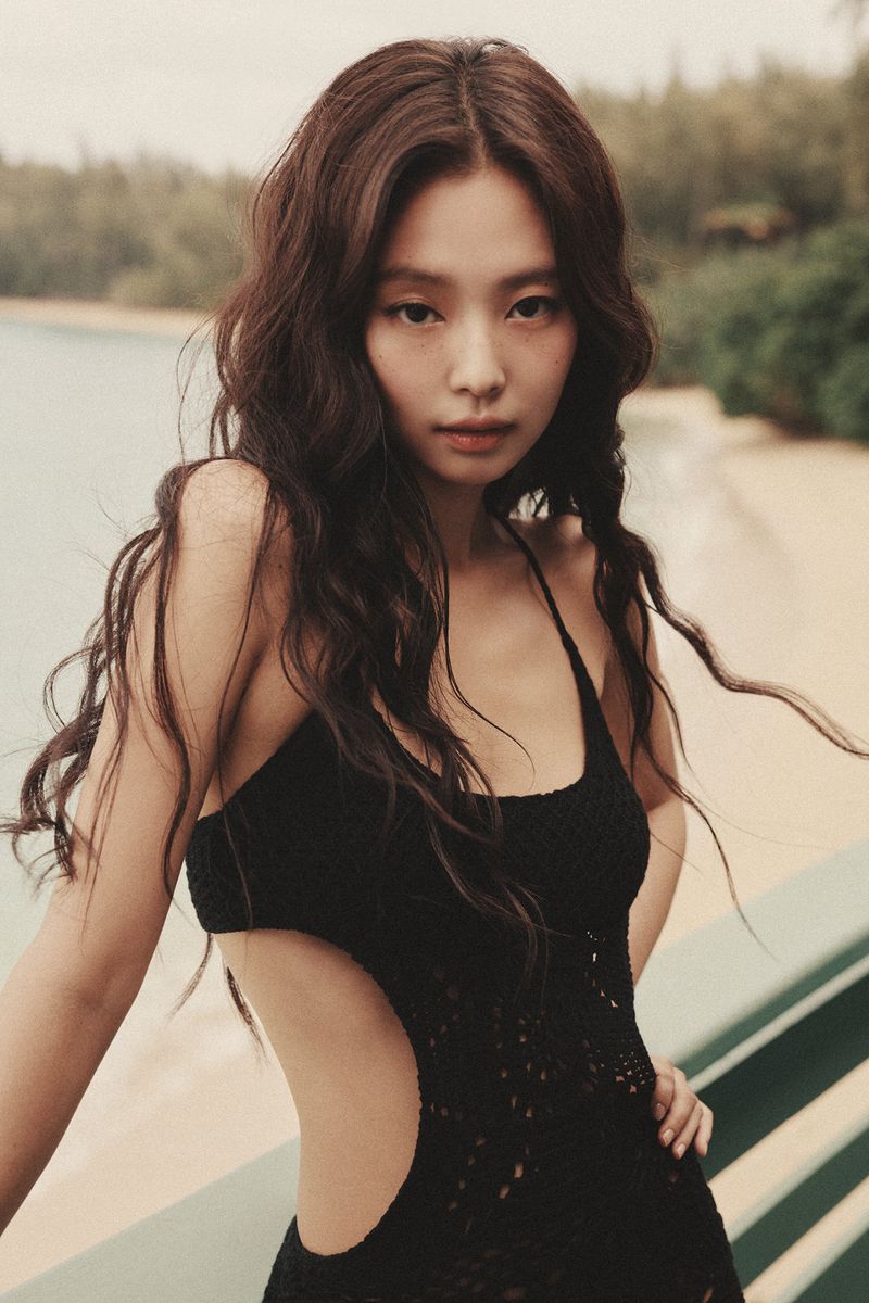 JENNIE wearing a black swimsuit against a sandy beach and ocean backdrop for Frankies Bikinis campaign