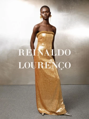 Model in a metallic gold strapless sequined gown against a textured silver background, photographed by Higor Bastos.