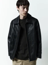 Model in black leather jacket and dark t-shirt against a plain white studio background for AGOLDE Man.