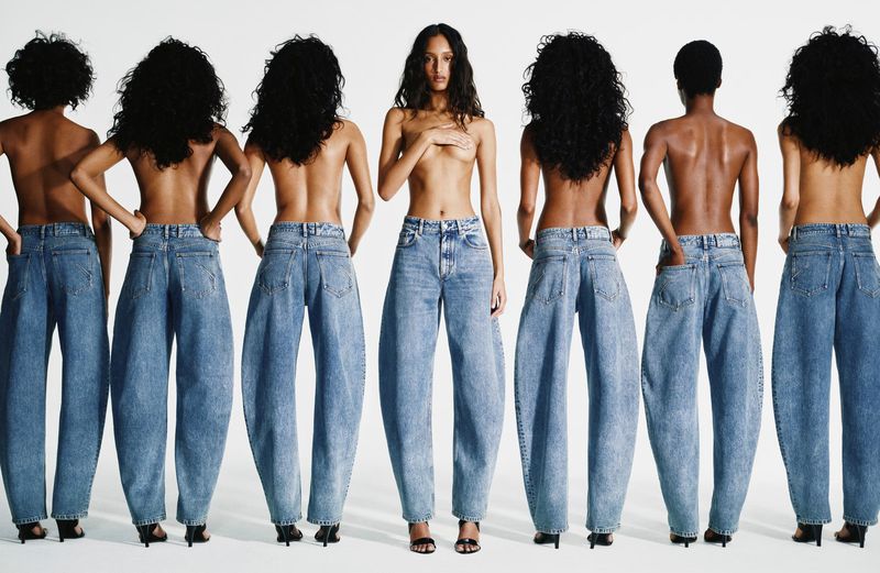 Multiple models posing in blue denim jeans against a seamless white studio background for Alaïa Denim 2026