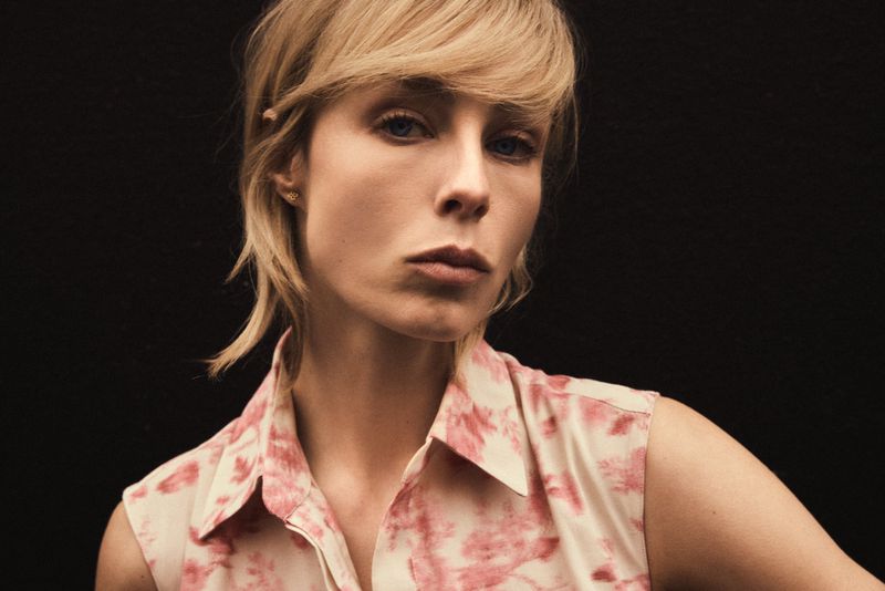 Edie Campbell in a pink patterned sleeveless top against a dark background for Carolina Herrera Matryoshka Pocket campaign.