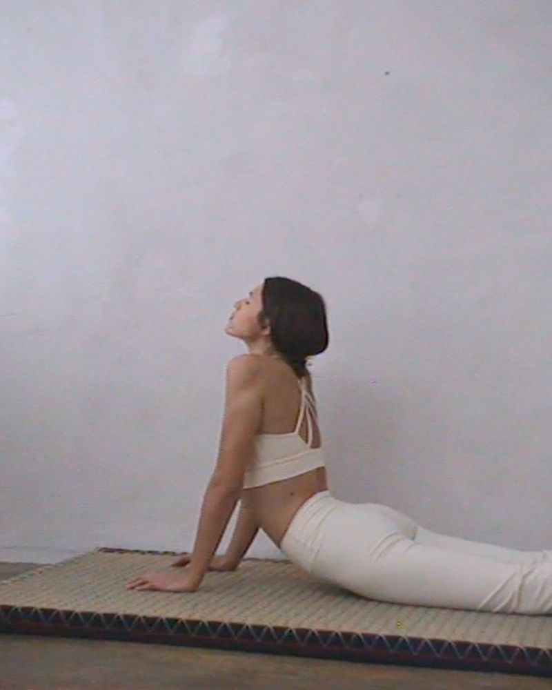 Model performing yoga stretch in cream activewear on a mat against a plain wall for H&M Move Cotton Active campaign