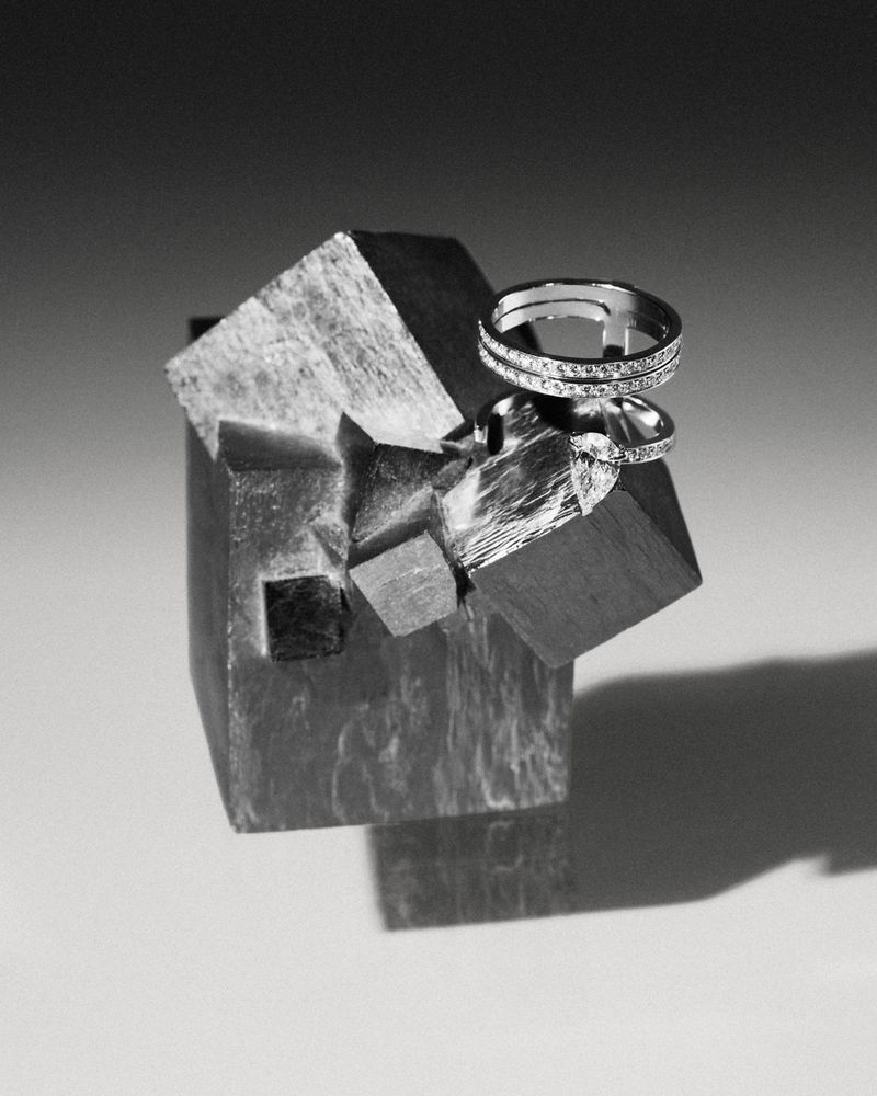 Close-up product shot of diamond rings resting on a crystalline mineral cluster against a gradient grey background