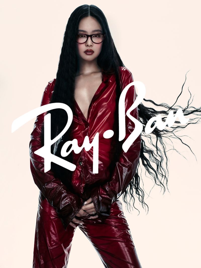 Jennie wearing dark red glossy shirt and matching trousers with eyeglasses against light background for Ray-Ban campaign