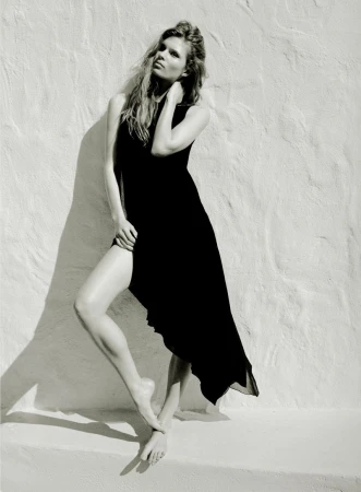 Model wearing a black dress posing against a textured white wall for Zara Women March 2026