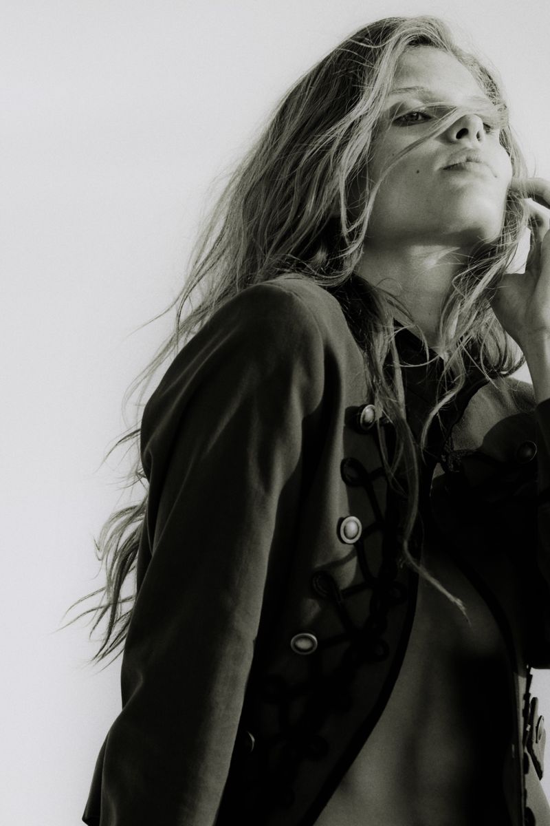 Monochrome portrait of model Ida Heiner wearing a dark buttoned jacket against a plain white background for Zara Women.