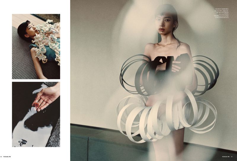 Editorial layout featuring a model wearing sculptural black and white circular garments with motion blur effects.
