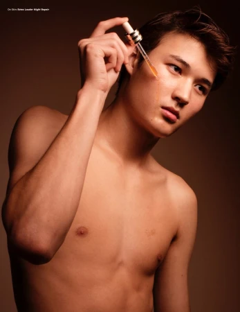 Shirtless man applying serum with a dropper to his cheek for a Desnudo Magazine editorial by B Charles Johnson.