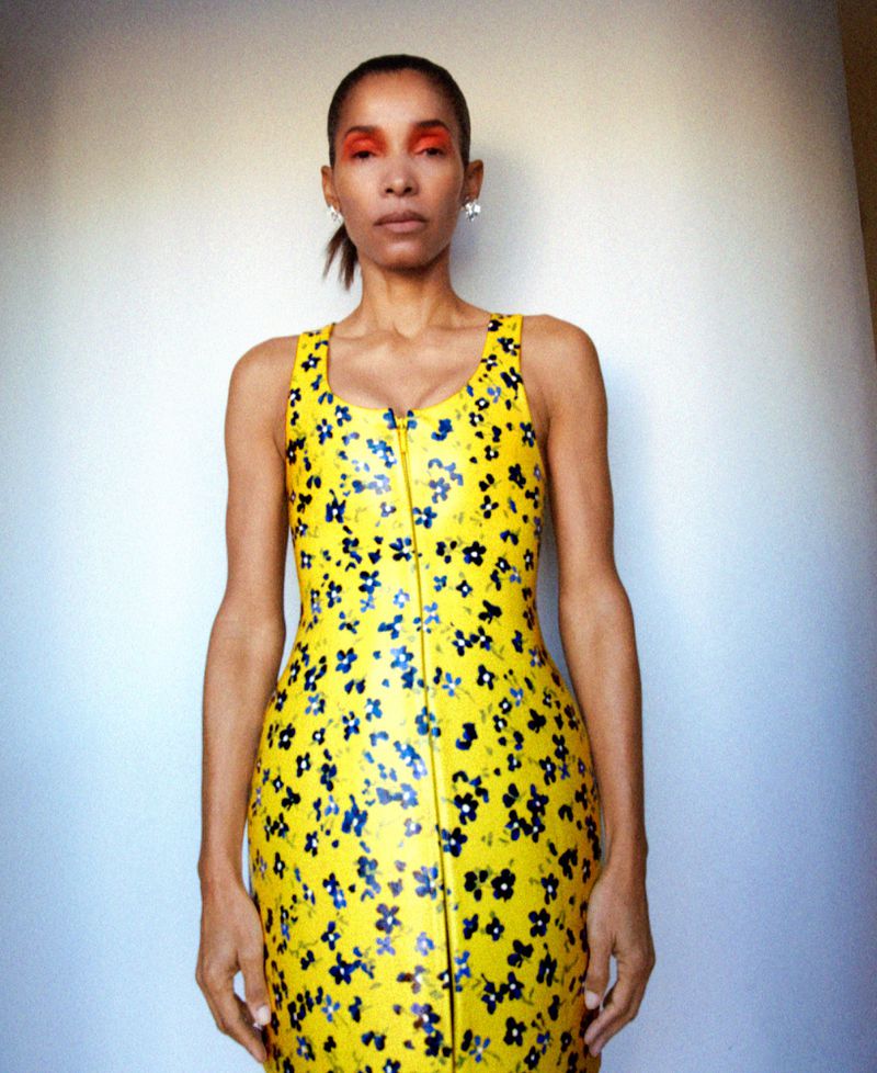 Model Romae Gordon wearing a yellow floral zip-up dress against a white studio wall for M Le magazine du Monde editorial.