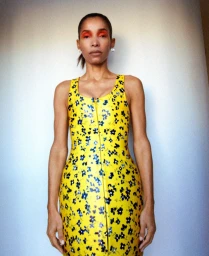 Model Romae Gordon wearing a yellow floral zip-up dress against a white studio wall for M Le magazine du Monde editorial.