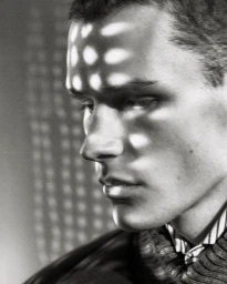 Monochrome portrait of a male model with distinctive patterned light cast across his forehead and face