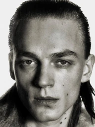 Close-up monochrome portrait of a young man with slicked-back hair and a textured collar against a bright white background.