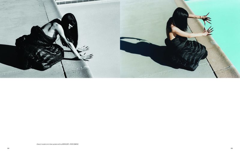 Model in black jacket with long dark hair and long nails kneeling by a swimming pool edge for Pop Magazine editorial